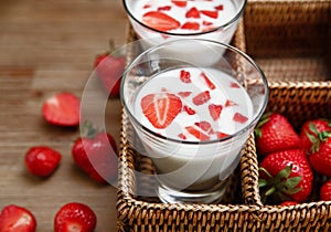 Two Glasses of Yogurt,Red Fresh Strawberries in the Rattan Box on the Wooden Table.Breakfast Organic Tasty Food.Cooking Vitamins