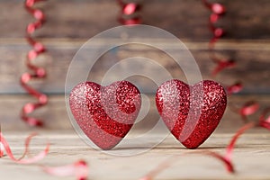 Two glitter hearts on vintage wooden table. Saint Valentines day greeting card. 14 February background.