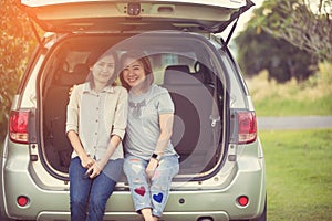 Two glorious lesbians relax on the car in park