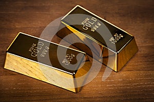 Two gold bars on wooden background