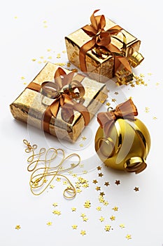 Two gold christmas or new year gift boxes on white background. New year ball with ribbon.