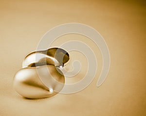 Two gold hearts isolated on golden background, concept of valentine day