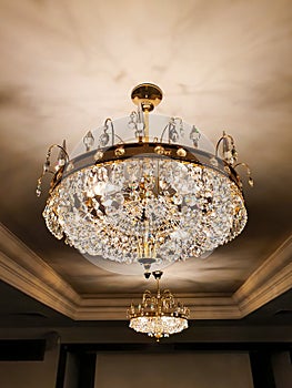 Two gold luxury classical chandeliers or lusters with crystal pendants. Shiny texture, front view, ceiling