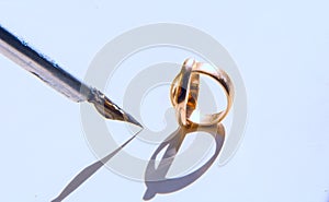 Two gold wedding rings and a fountain pen illuminated by the sun