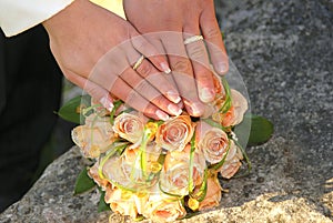 Two gold wedding rings on roses bouquet