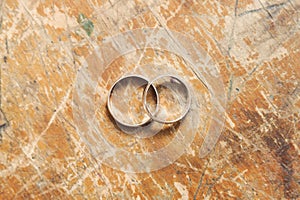 Two gold wedding rings on vintage backgrounds