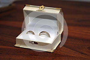 Two gold wedding rings in the white ring box
