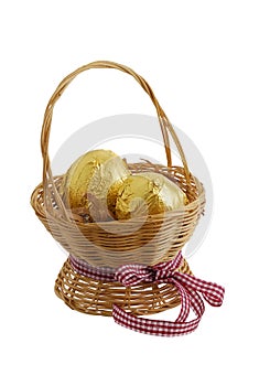 Two golden eggs in straw basket