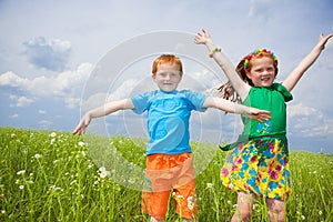 Two golden-haired children playin the field