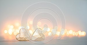 Two golden hearts on a background of bokeh lights. Valentine's day background