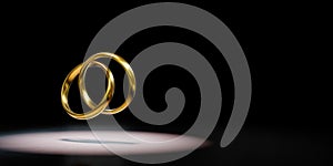 Two Golden Rings Chained Spotlighted on Black Background 3D Illustration