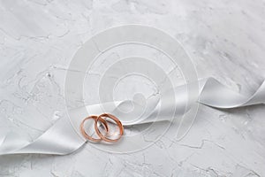 Two golden rings and white satin ribbon
