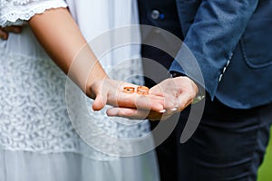 Two golden wedding rings on bride and groom`s palms. Wedding rings on the palm. Bride and groom hold wedding rings on their palms