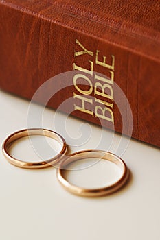 Two golden wedding rings and a holy bible represents the concept of marriage and the love between two Christians