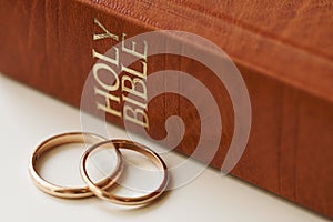 Two golden wedding rings and a holy bible represents the concept of marriage and the love between two Christians