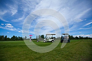 Two golf carts on the golfe course in summer