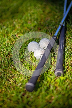 Two golf clubs and  balls on the grass