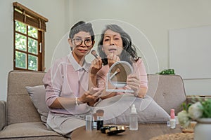 Two good looking elderly women asian looking happy and joyful with beautifying each other