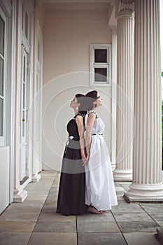 Two gorgeous girls in black and white long dresses photo