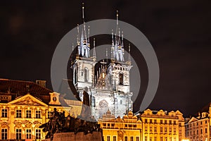 Two gothic towers of Church Of Our Lady Before Tyn and Jan Hus Memorial at Old Town Square by night. Prague, Czech