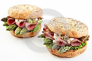 Two gourmet asparagus burgers with parma ham