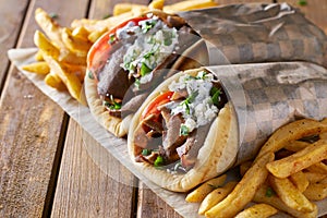 Two greek gyros with shaved lamb and french fries