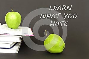 Two green apples and open books with text learn what you hate