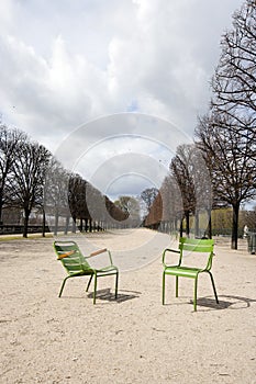 Two Green Chairs on a path In Paris, France