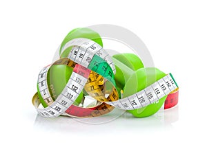 Two green dumbells and tape measure. Fitness and health