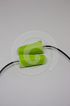 Two green ear plugs on a white background. Close-up