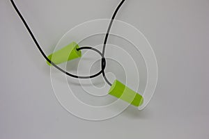 Two green ear plugs on a white background. Close-up