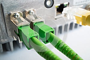 Two green optical patch cords inserted into the green optical ports