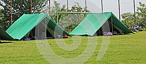 Two green tents mounted in a meadow by the scouts photo