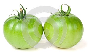 Two green unripe tomato isolated on white background