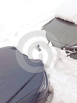 Two grey cars buried under snow