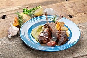 Two grilled lamb chops and potatoes served on pea puree with a mint sauce