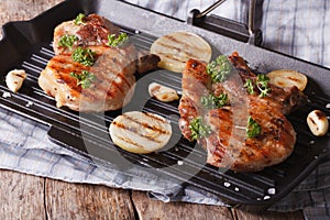 Two grilled pork steak in a pan grill close-up. horizontal
