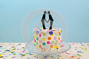 Two grooms cake toppers on decorated wedding cake. Gay wedding concept LGBTQIA