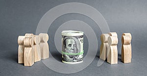 Two groups of people are divided by a bundle roll dollars. Investment concept. High profits and a welcome item. The cult of money