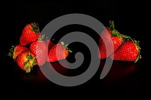 Two groups of strawbarries on black background