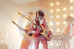 Two guitarists performing in a studio