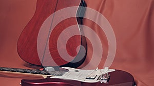 Two guitars and a microphone lie on a scarlet cloth photo