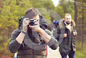 Two guys with backpacks walking in swamps and taking pictures. C