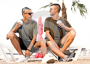 Two guys drink cocktails on a tropical beach