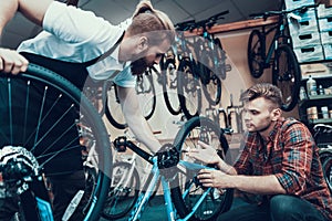 Two Guys Examine Bicycle in Sport Workshop