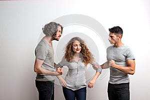 Two guys fighting over a girl, a studio shot.