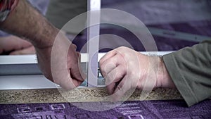 Two guys inserting the nails into the bed frame