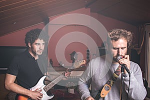 Two guys playing the electric guitar and singing