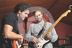 Two guys playing the electric guitar and singing