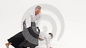 Two guys showing aikido using tanto. Isolated, white. Close up. Close up. Slow motion.